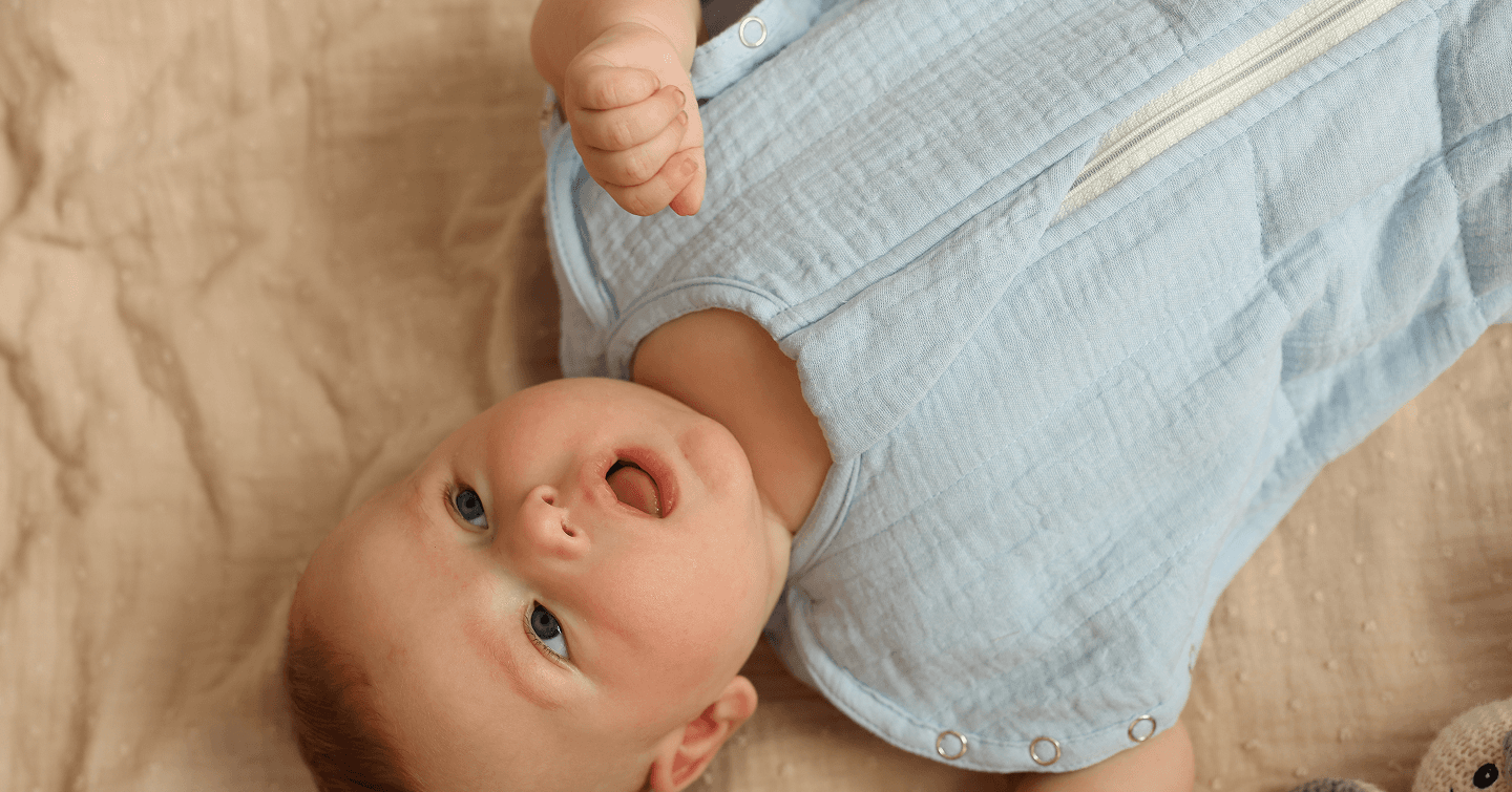 Baby lying down wearing a Lullaboo weighted sleeping bag