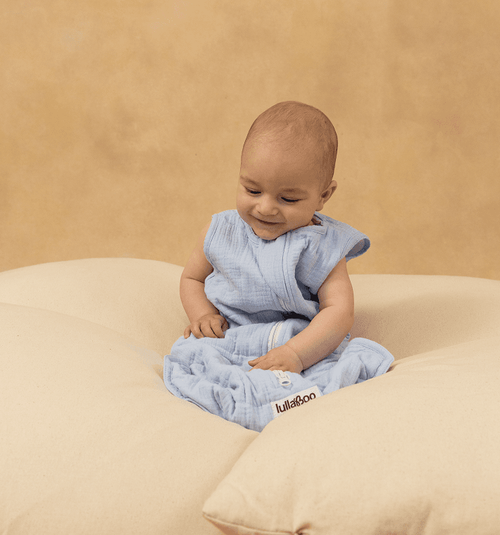 Baby sitting in a Lullaboo weighted sleeping bag